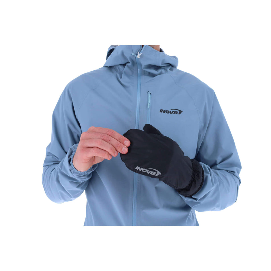 A model wearing the left glove from a pair of INOV8 Unisex Waterproof Overmitts in the Black colourway. (8523660066978)