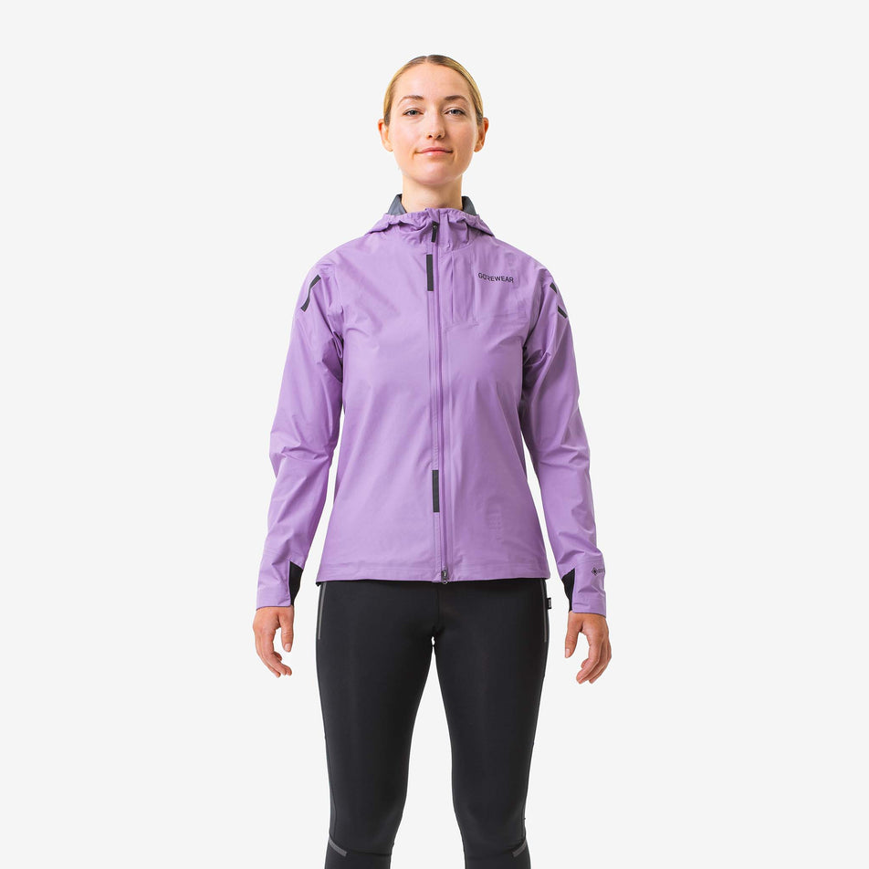 Front view of a model wearing a GOREWEAR Women's Concurve GORE-TEX Jacket in the Scrub Purple colourway. Model is also wearing leggings. (8177157079202)