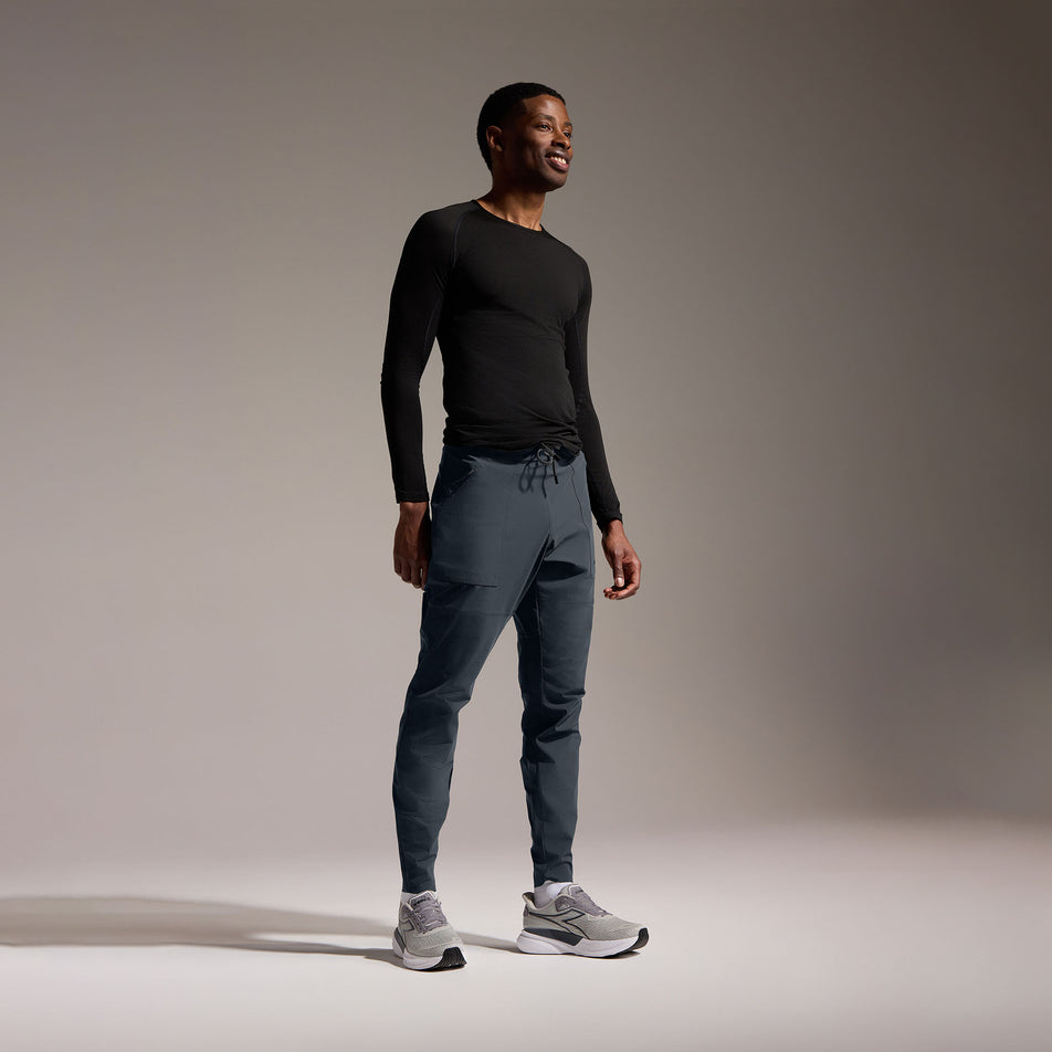 Angled view of a model wearing the GOREWEAR Men's Everyday Track Pants in the Lab Graphite colourway. (8752076423330)