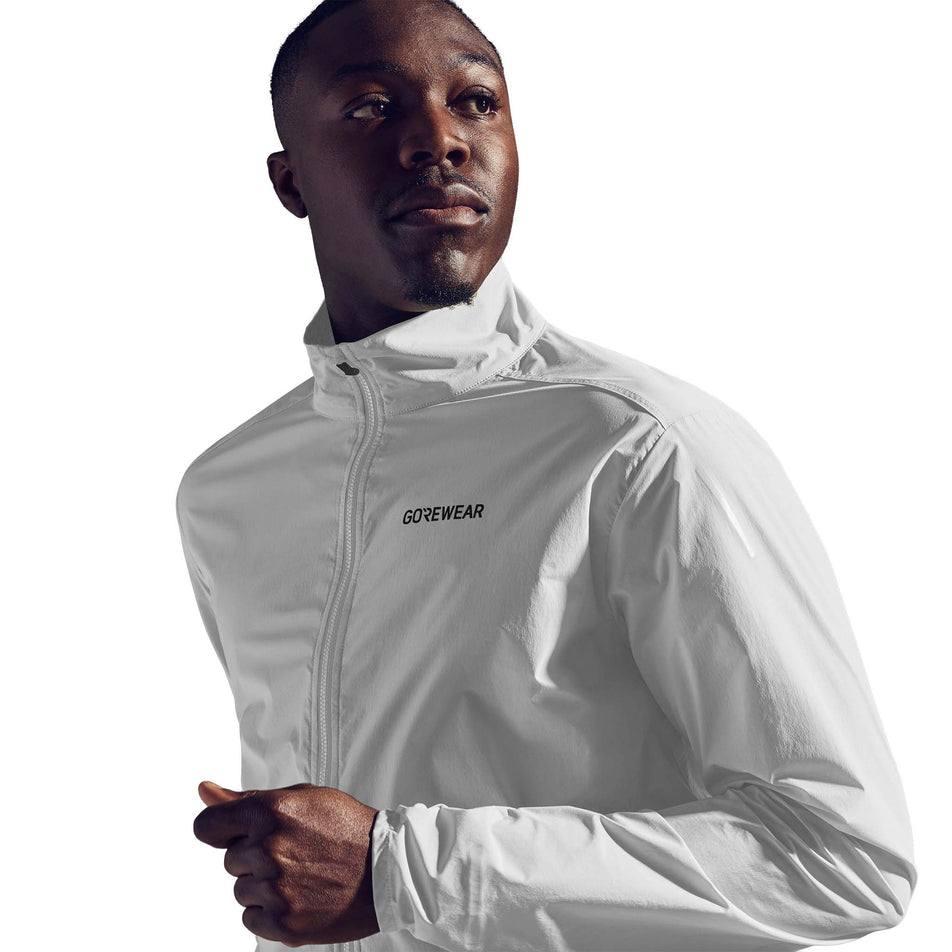 Angled view of a model wearing the GOREWEAR Men's Concurve Windbreaker in the White colourway. (8751744319650)
