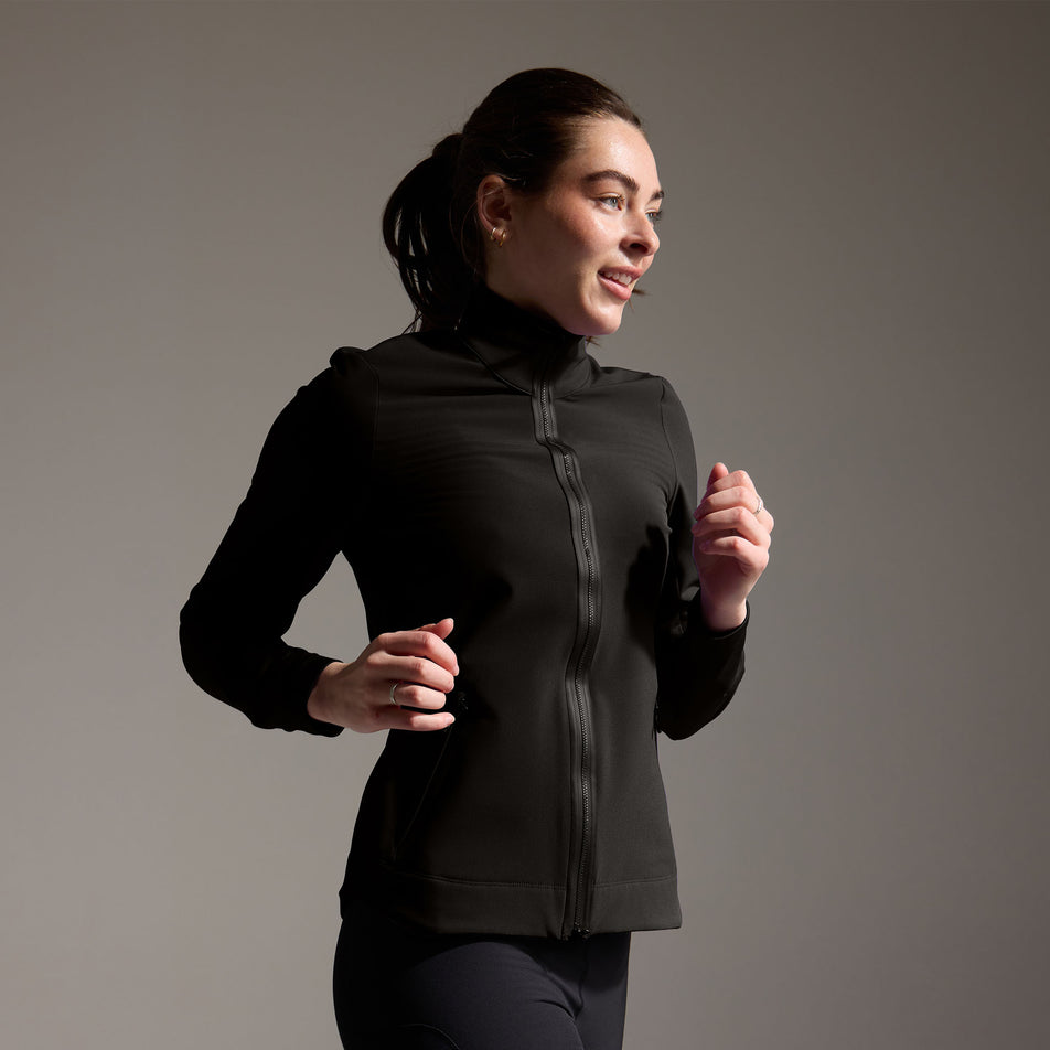 Angled view of a model wearing the GOREWEAR Women's Concurve Thermo Hybrid Jacket in the Black colourway. (8752085106850)