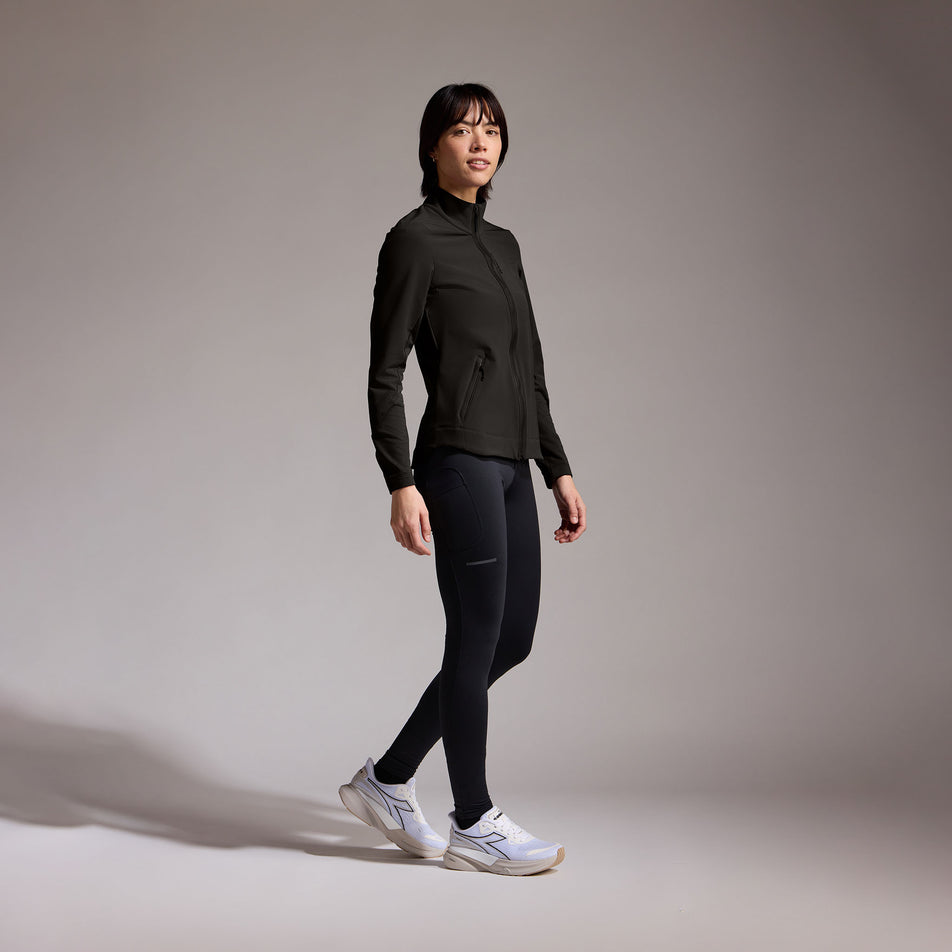 Angled view of a model wearing the GOREWEAR Women's Concurve Thermo Hybrid Jacket in the Black colourway. (8752085106850)