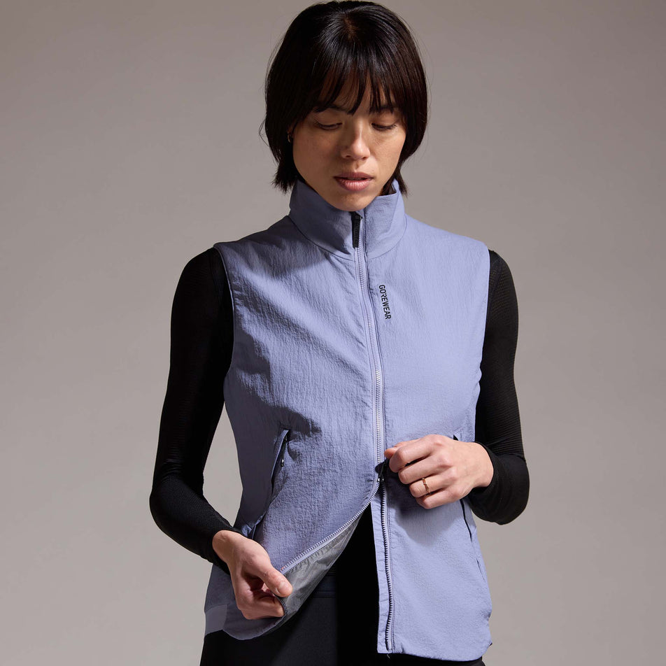 Front view of a model wearing the GOREWEAR Women's Concurve WINDSTOPPER Insulated Vest in the Amethyst Grey colourway. (8752085926050)