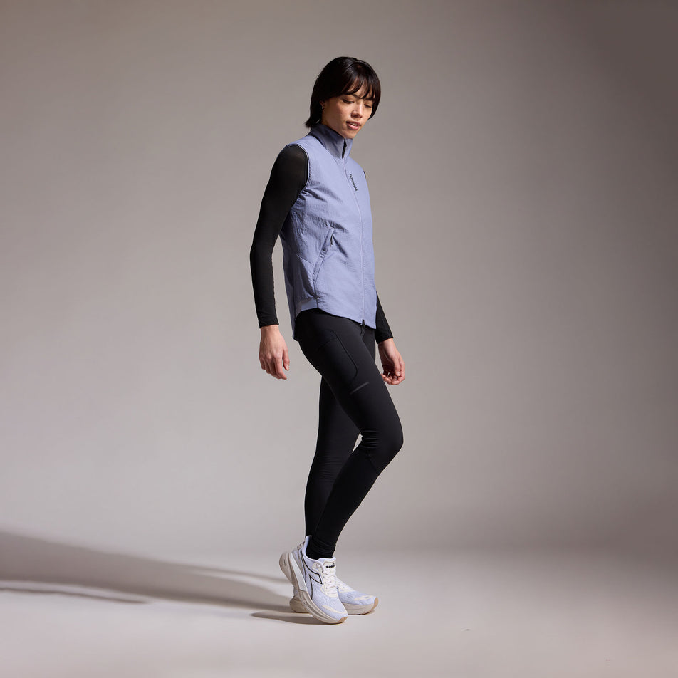 Angled view of a model wearing the GOREWEAR Women's Concurve WINDSTOPPER Insulated Vest in the Amethyst Grey colourway. (8752085926050)
