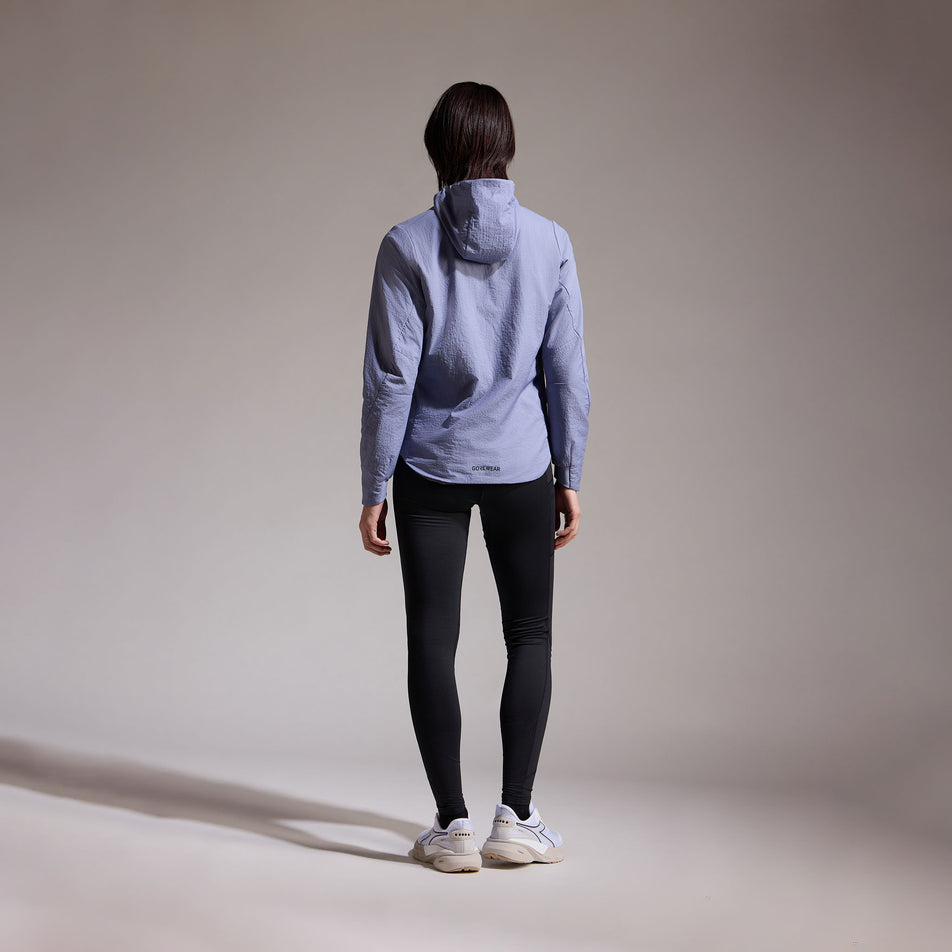 Back view of a model wearing the GOREWEAR Women's Concurve WINDSTOPPER Insulated Hooded Jacket in the Amethyst Grey colourway. (8752083796130)