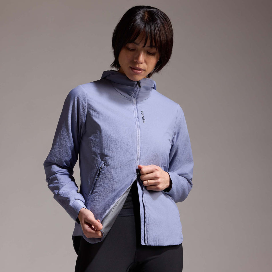 Front view of a model wearing the GOREWEAR Women's Concurve WINDSTOPPER Insulated Hooded Jacket in the Amethyst Grey colourway. (8752083796130)