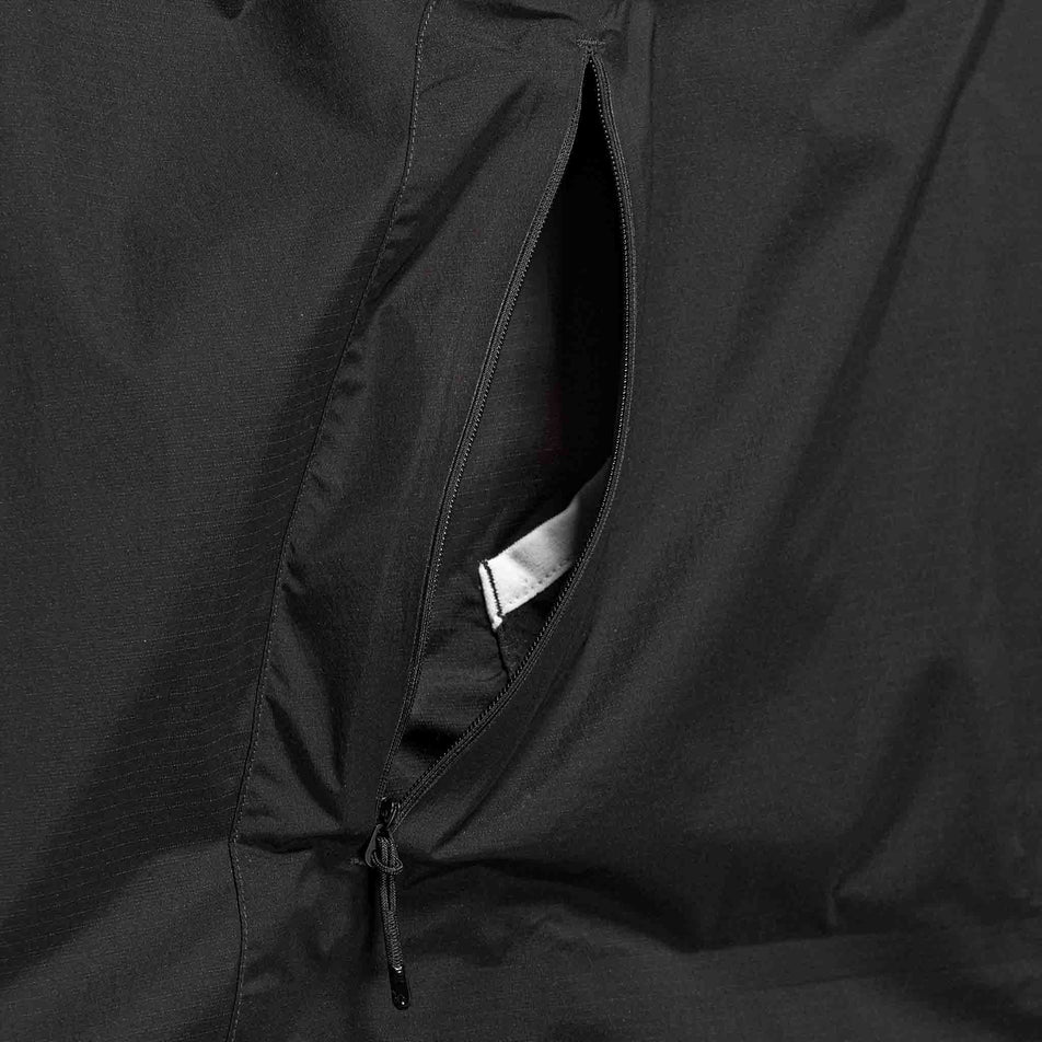The zip pocket on the GOREWEAR Men's Concurve Windbreaker Anorak in the Black colourway.