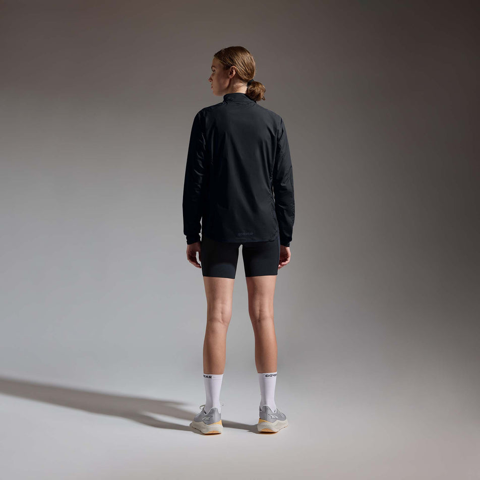 Back view of a model wearing the GOREWEAR Women's Concurve Windbreaker Anorak in the Black colourway.