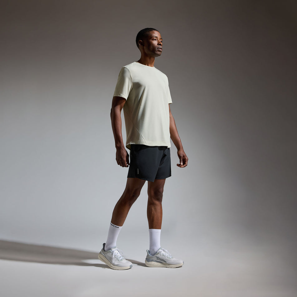 Angled view of a model wearing the GOREWEAR Men's Training Tee in the Tech Beige colourway.