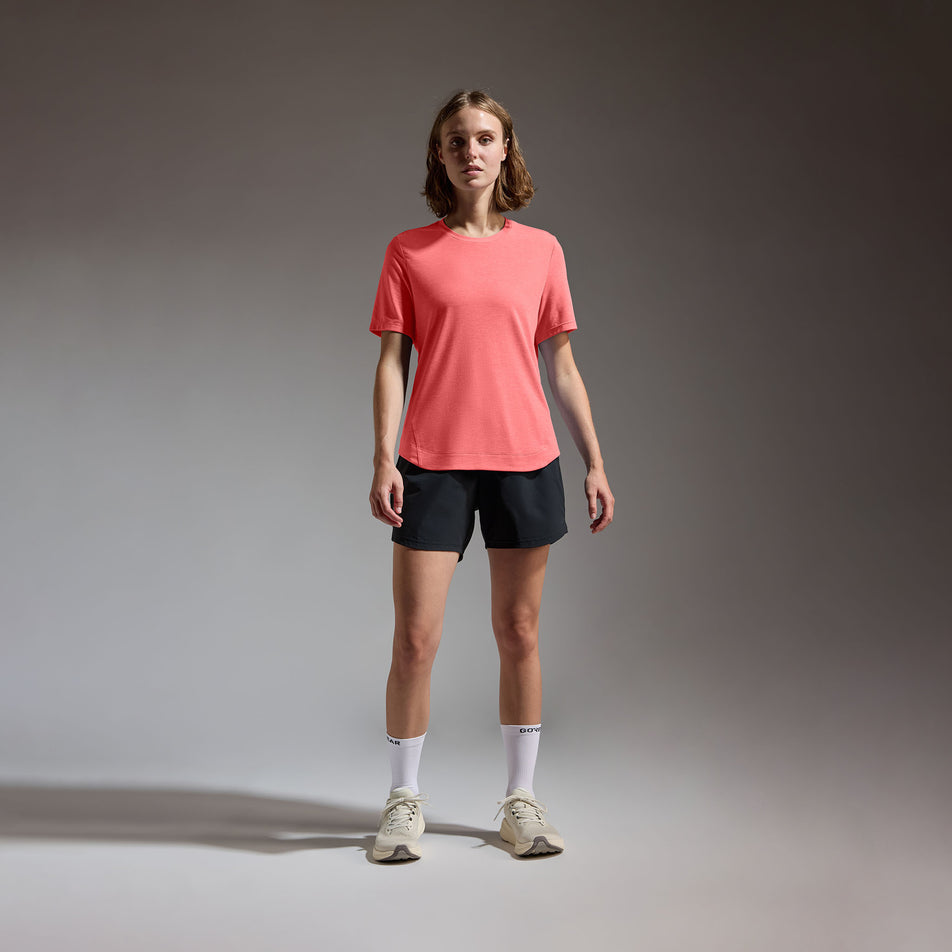 Front view of a model wearing the GOREWEAR Women's Training Tee in the Coral Red colourway.