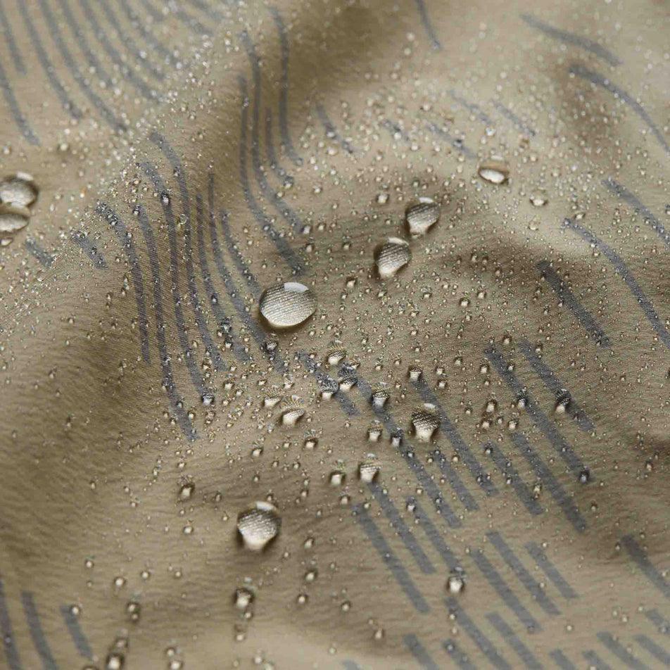 Water sitting on the fabric of the GOREWEAR Men's Concurve Electro Windbreaker in the Crushed Tech Beige/Lab Gray colourway.