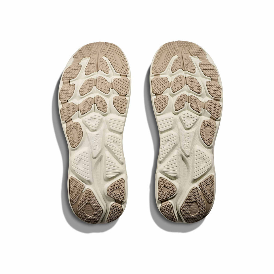 The outsoles of a pair of HOKA Men's Clifton 10 Running Shoes in the Raw Linen/Stone colourway. (8689189421218)