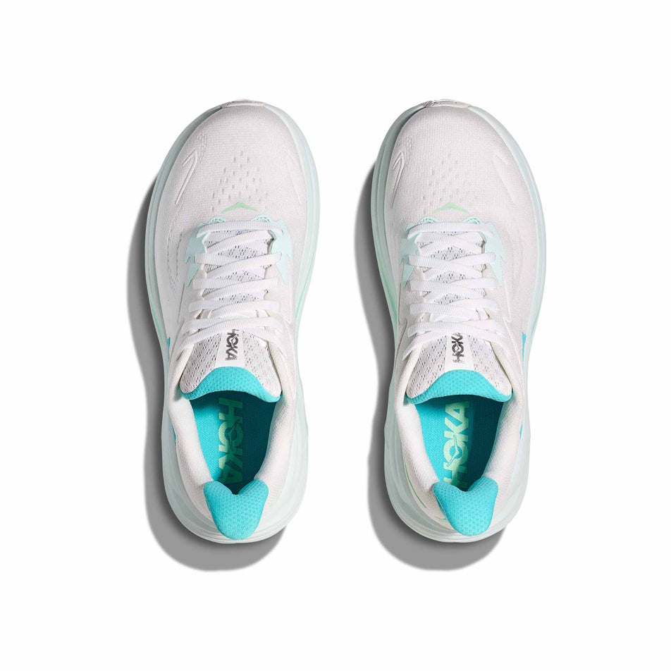 The uppers of a pair of HOKA Women's Clifton 10 Running Shoes in the White/Cielo Blue colourway. (8637769875618)