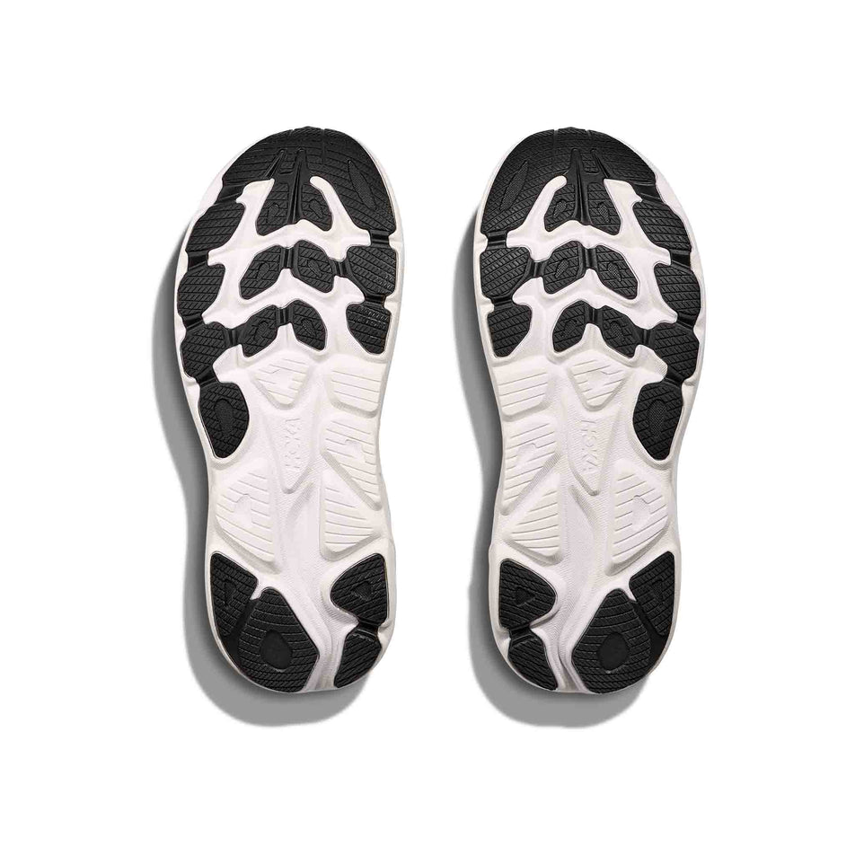 The outsoles of a pair of HOKA Women's Clifton 10 Wide Running Shoes in the Black/White colourway. (8637785374882)