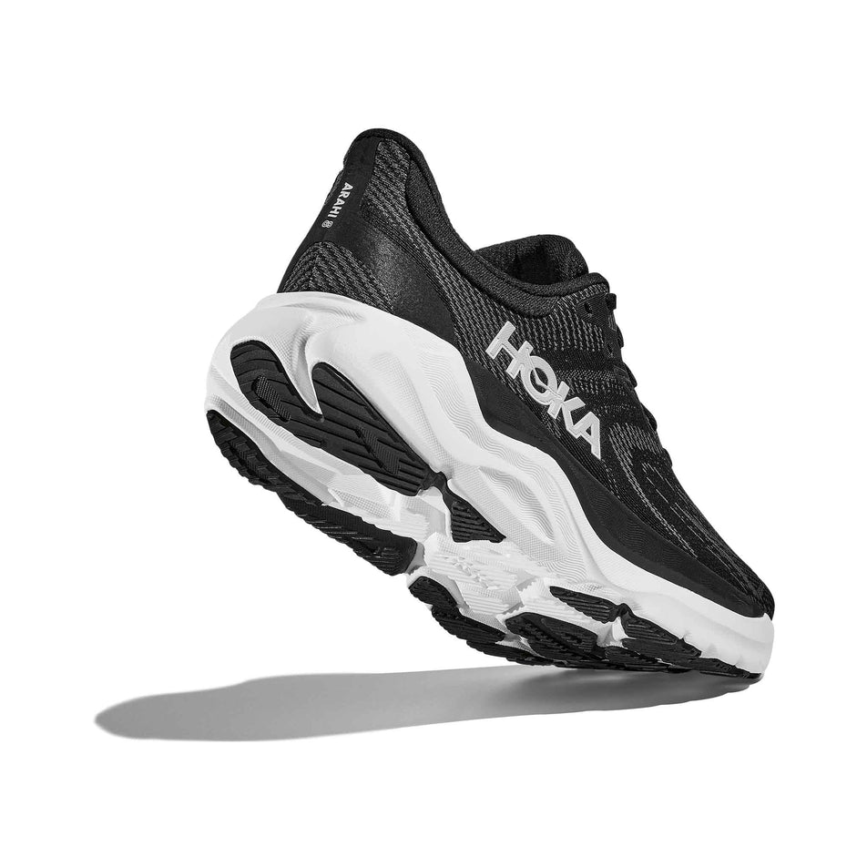 Lateral - and outsole - view of the right shoe from a pair of HOKA Women's Arahi 8 Wide Running Shoes in the Black/White colourway. (8689328947362)