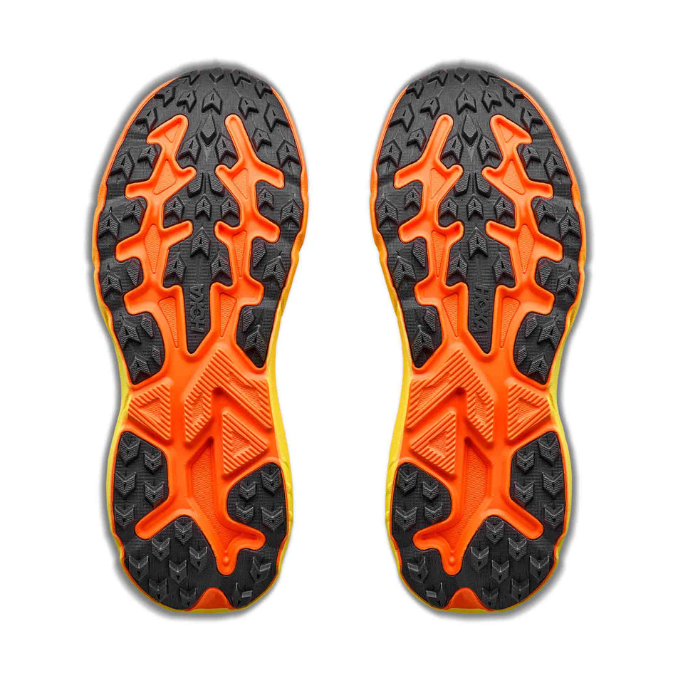 The outsoles of a pair of HOKA Men's Challenger 8 Running Shoes in the Neon Tangerine/Hoka Citrus colourway.