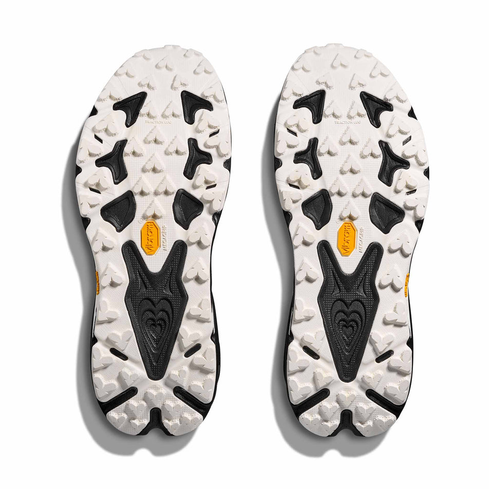 The outsoles of a pair of HOKA Women's Speedgoat 7 Running Shoes in the Black/White colourway.