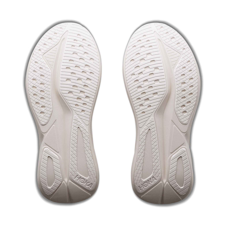 The outsoles of a pair of HOKA Women's Mach 7 Running Shoes in the Oat Milk/Alabaster colourway.