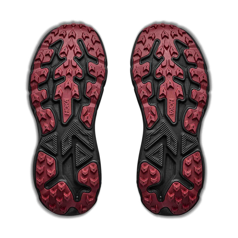 The outsoles of a pair of HOKA Women's Challenger 8 GTX Trail Running Shoes in the Black/Varsity Burgundy colourway.