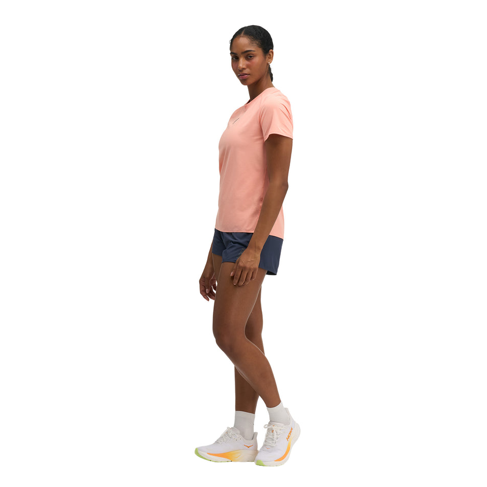 Angled view of a model wearing the HOKA Women's Everyrun Short Sleeve in the Sunstone colourway.