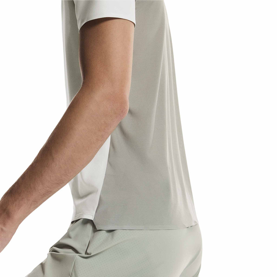 Side view of a model wearing the On Men's Performance-T in the Iceberg/Tin colourway.