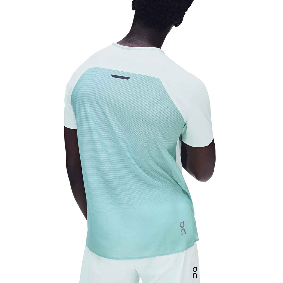 Back view of a model wearing the On Men's Performance-T in the Flurry/Aquamarine colourway.