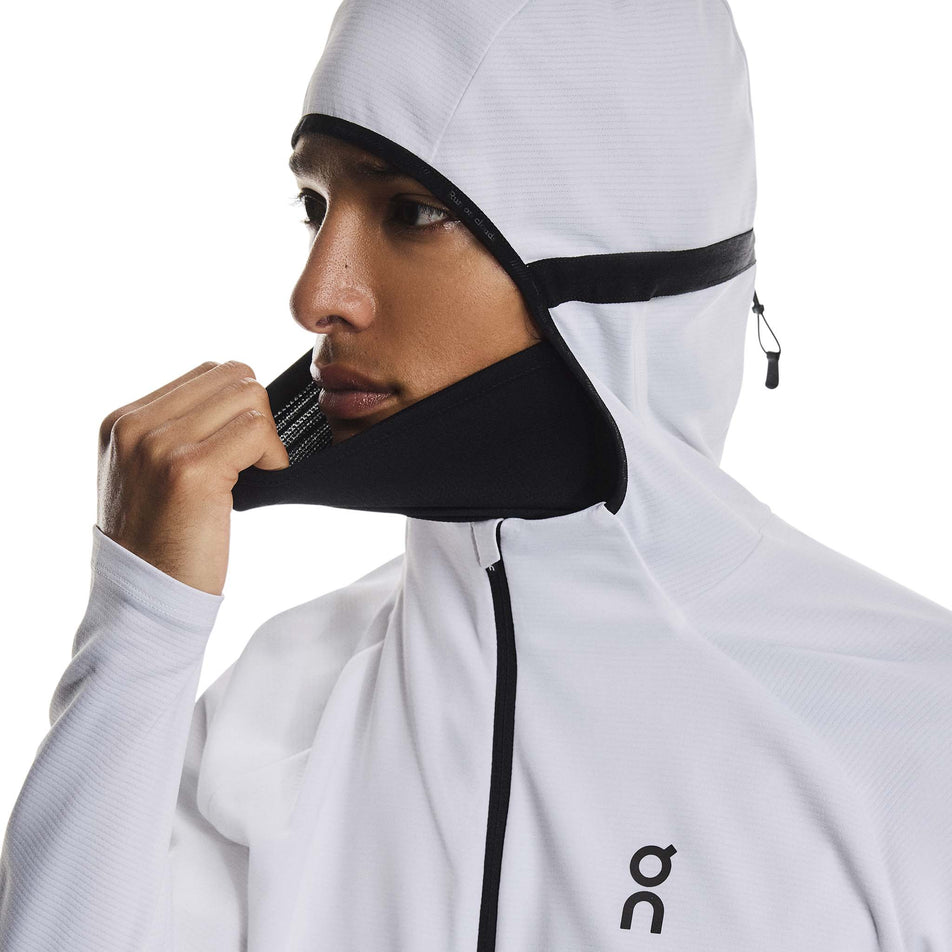 A model demonstrating the neck gaitor on the On Men's Climate Zip Hoodie in the White colourway.