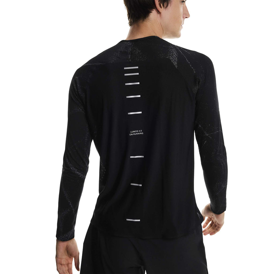 Back view of a model wearing the On Men's Performance Long-T Lumos in the Black colourway. (8790118105250)