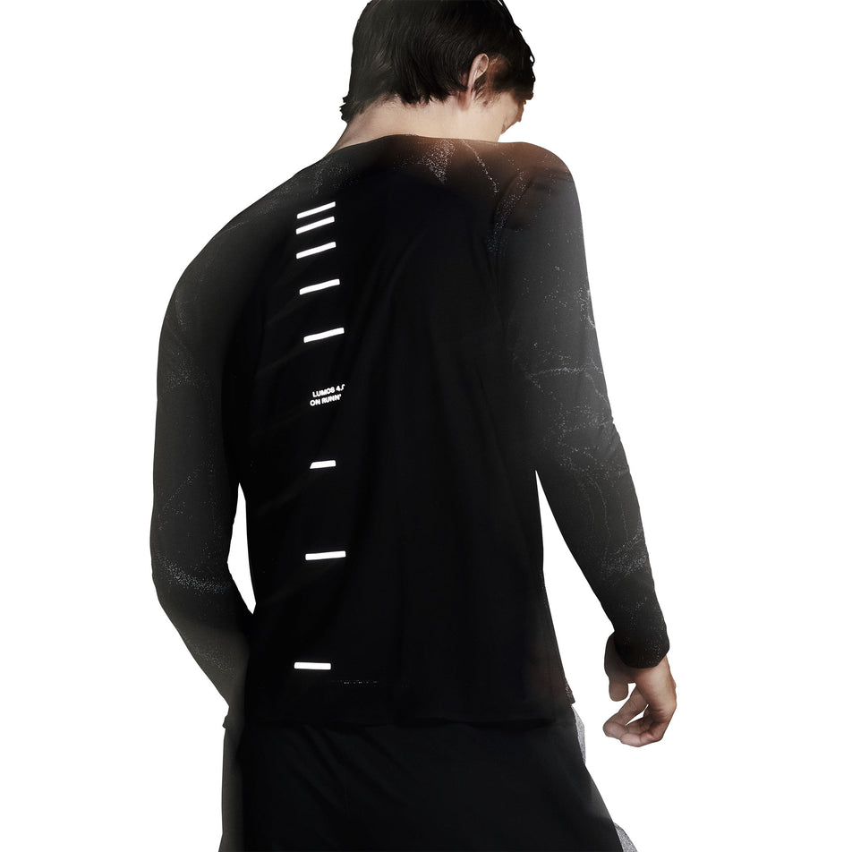 Back view of a model wearing the On Men's Performance Long-T Lumos in the Black colourway. (8790118105250)