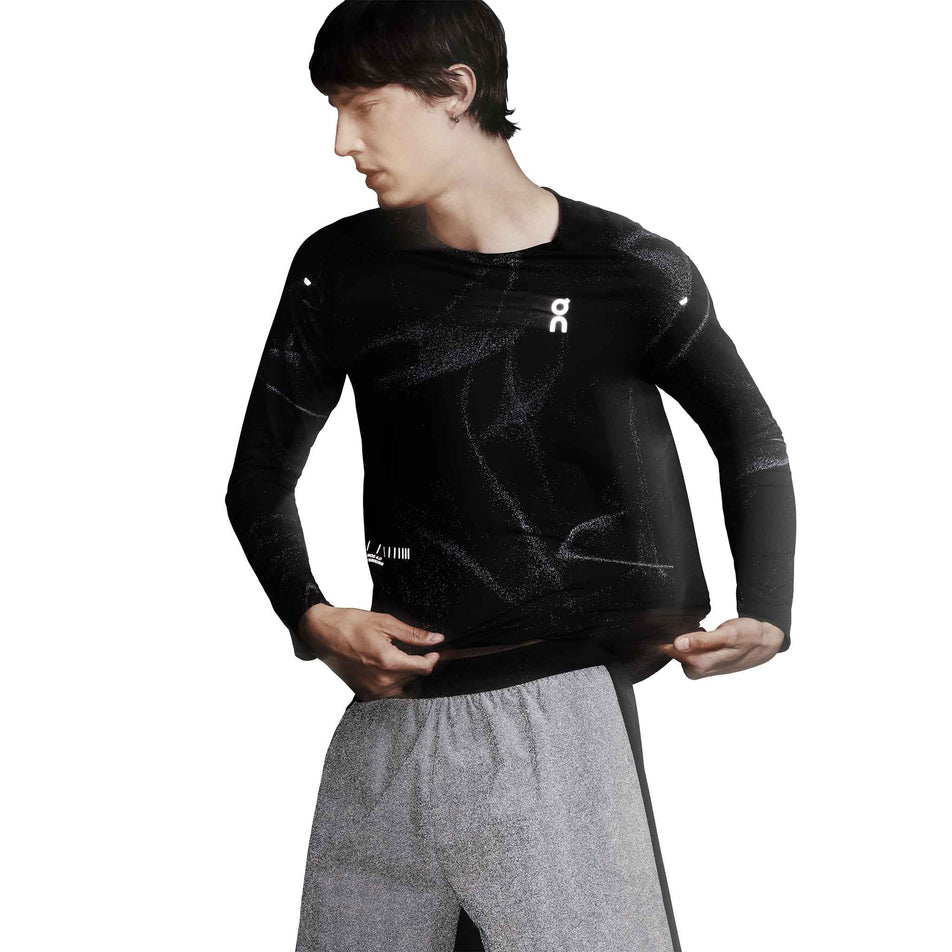 Front view of a model wearing the On Men's Performance Long-T Lumos in the Black colourway. (8790118105250)