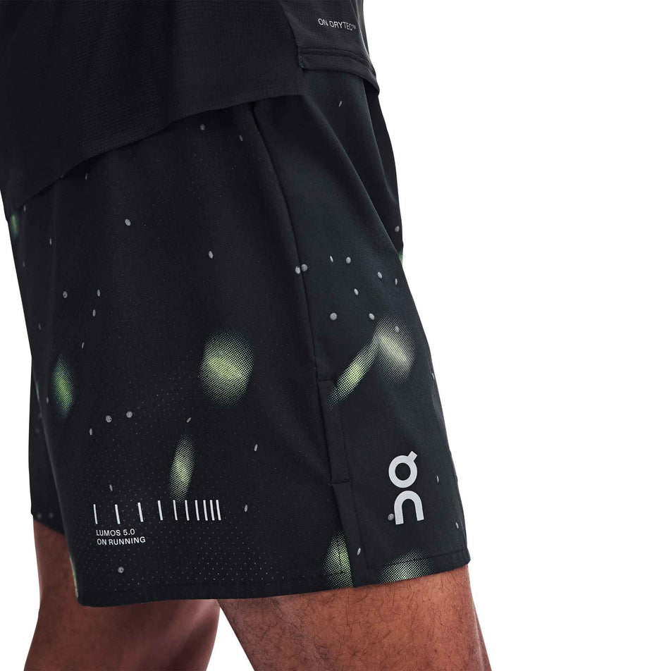 Side view of a model wearing the On Men's Performance Shorts Lumos 2.0 in the Black colourway.