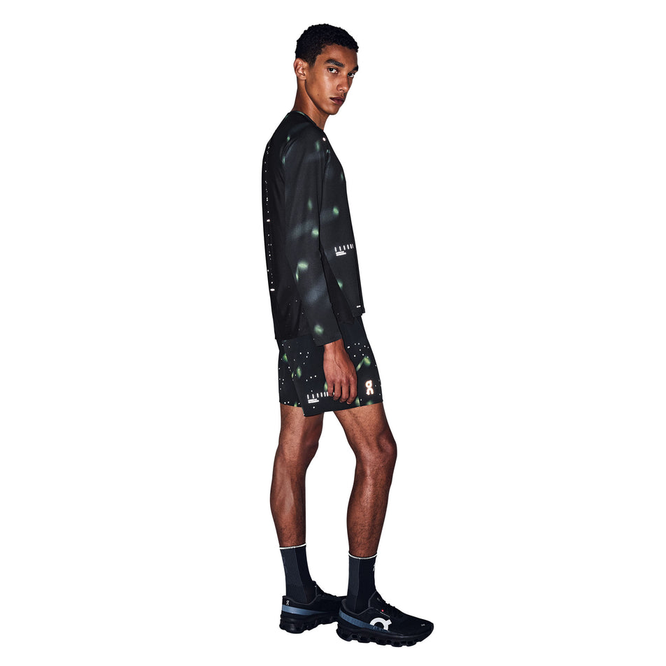 Angled view of a model wearing the On Men's Performance Shorts Lumos 2.0 in the Black colourway.