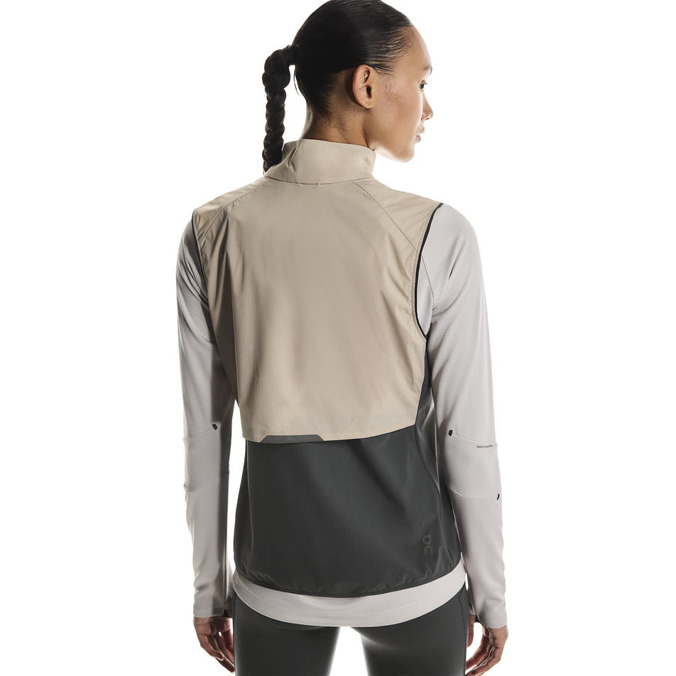 Back view of a model wearing the On Women's Weather Vest in the Desert/Eclipse colourway. (8790011412642)