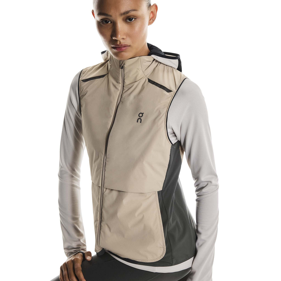 Front view of a model wearing the On Women's Weather Vest in the Desert/Eclipse colourway. (8790011412642)