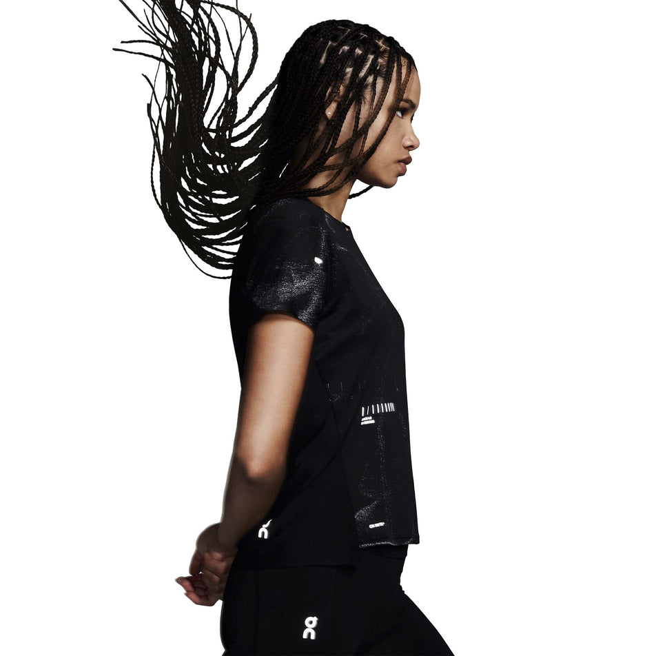 Side view of a model wearing the On Women's Performance-T Lumos in the Black colourway. (8790019342498)