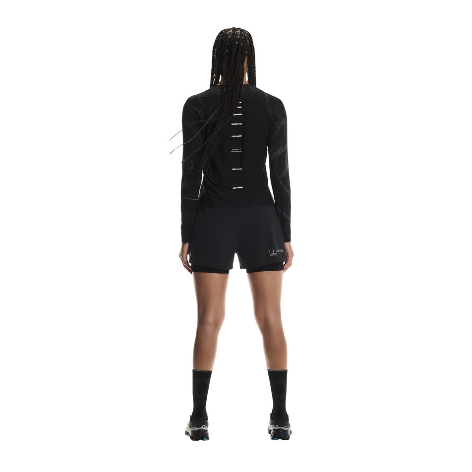 Back view of a model wearing the On Women's Performance Long-T Lumos in the Black colourway. (8790025928866)