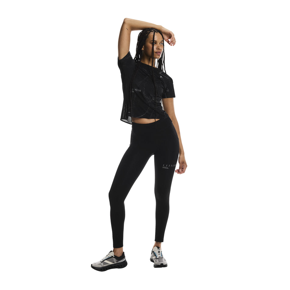 Front view of a model wearing the On Women's Performance Tights Lumos in the Black colourway. (8790043394210)