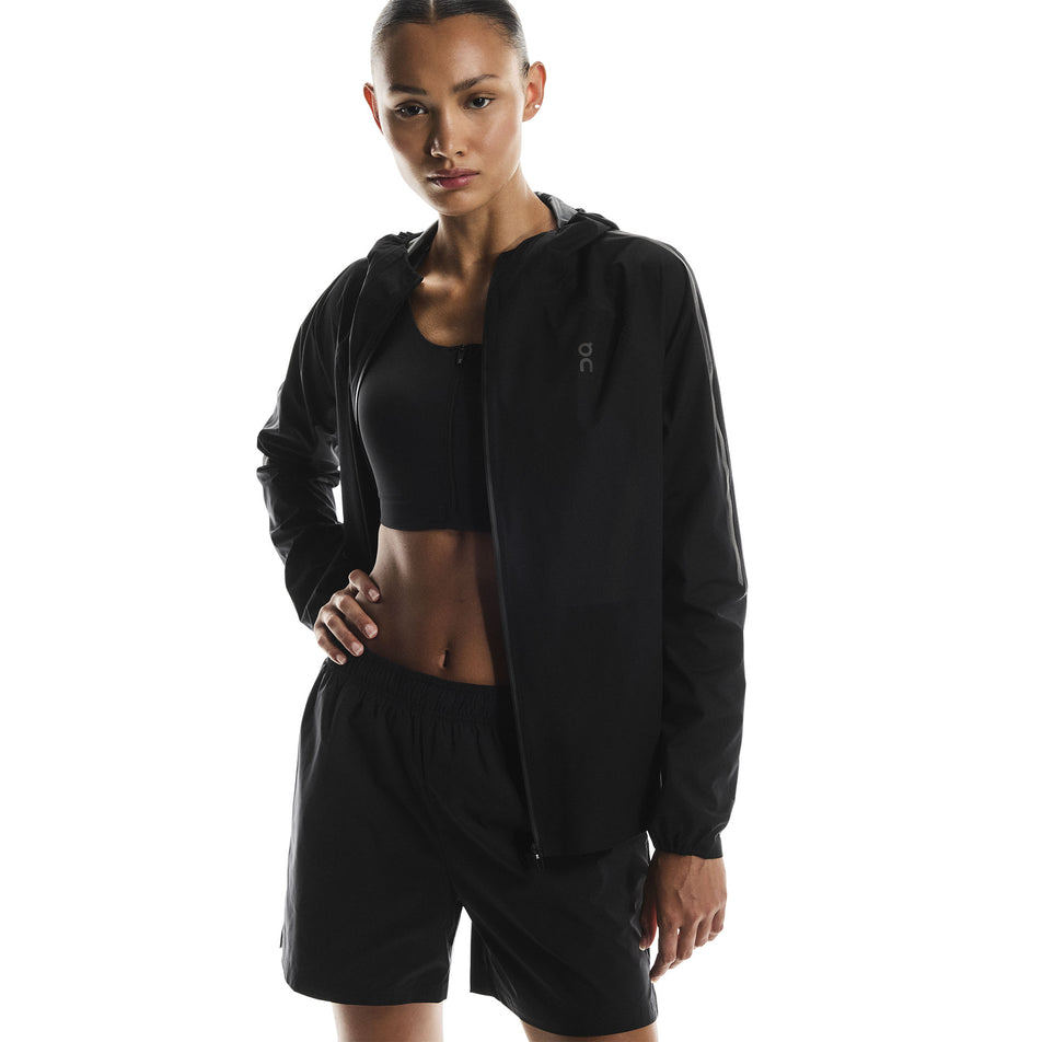 Front view of a model wearing the On Women's Performance Waterproof Jacket in the Black colourway. (8790002696354)