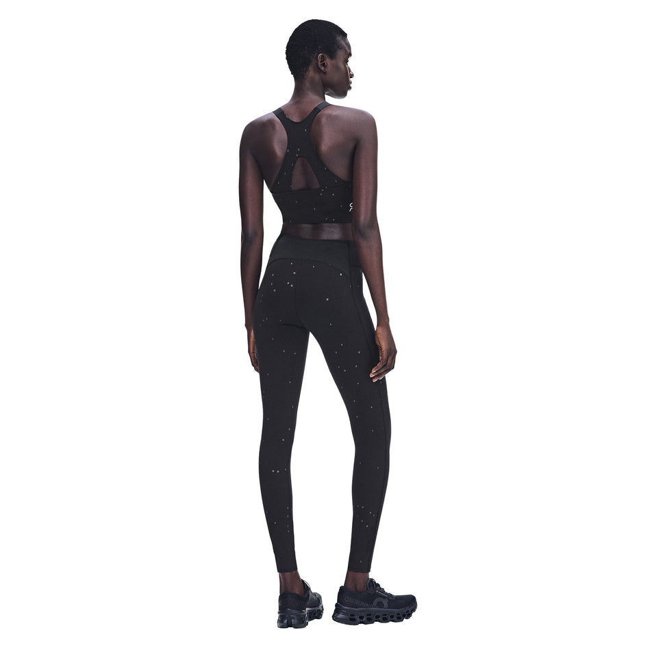 Back view of a model wearing the On Women's Performance Tights Lumos 2.0 in the Black/Eclipse colourway.