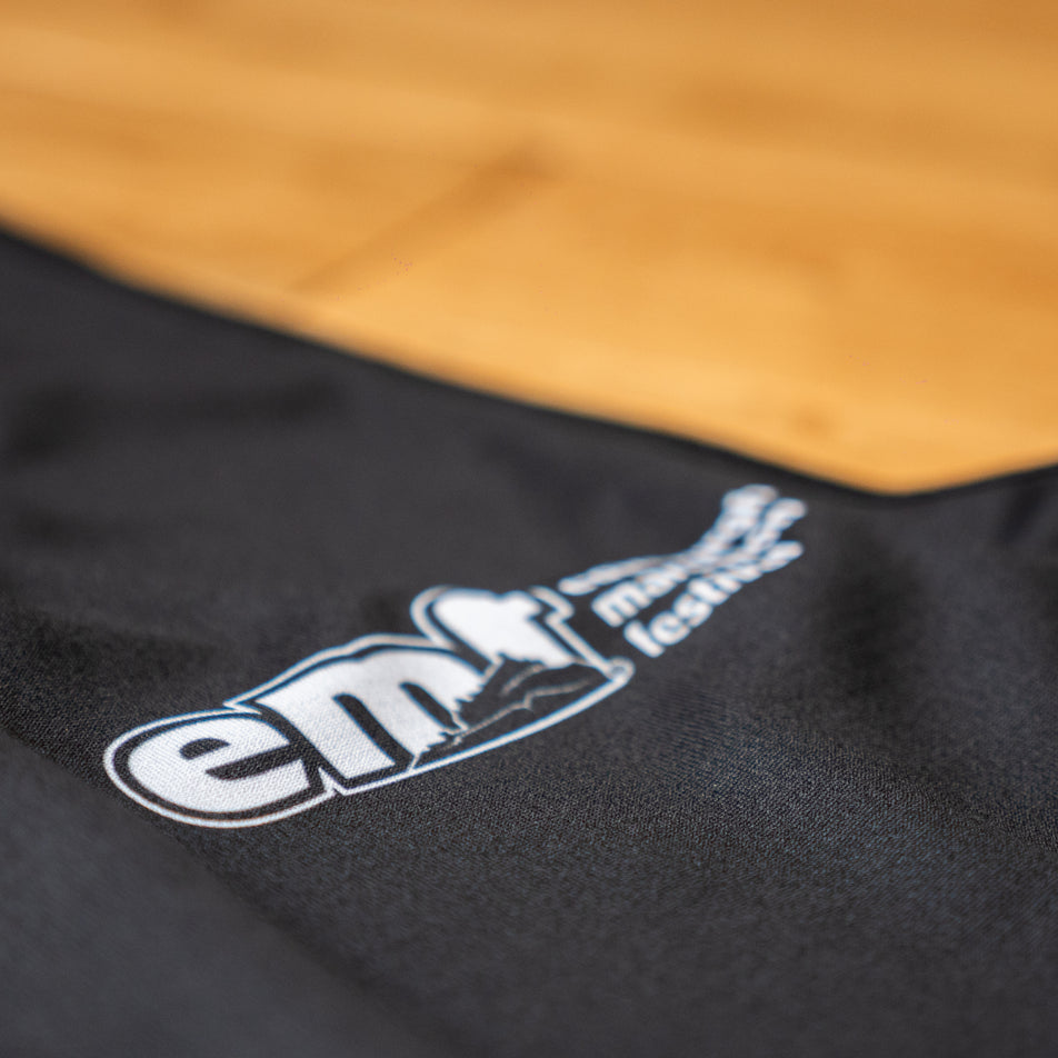 Close-up view of the EMF logo on the EMF Official Licensed Merchandise | Pressio Women's Prevail Singlet in the Black/Pink colourway.
