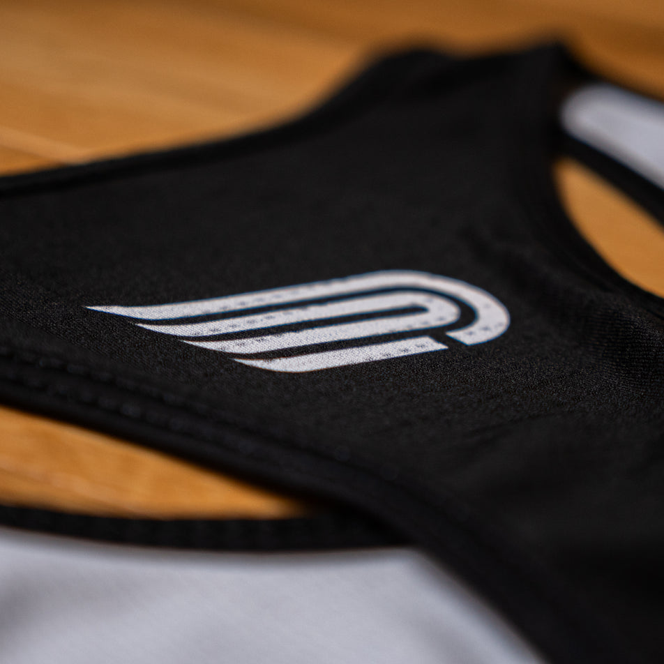 Close-up view of the Pressio logo on the EMF Official Licensed Merchandise | Pressio Women's Prevail Singlet in the Black/Pink colourway.
