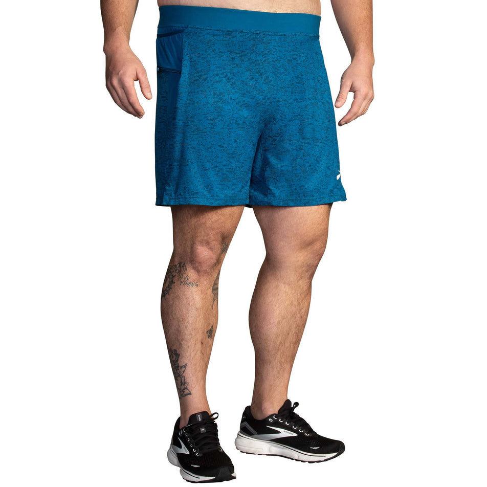 Front view of a model wearing a pair of Brooks Men's Sherpa 7 Inch 2-in-1 Shorts in the Dark Ocean Terrain Print colourway (8007477133474)