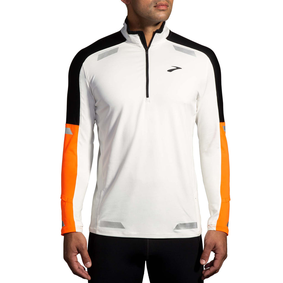 Front view of a model wearing the Brooks Men's Run Visible 1/2 Zip 2.0 in the Ecru/Fluoro Flash/Black colourway. Model is also wearing Brooks tights. (8499413188770)
