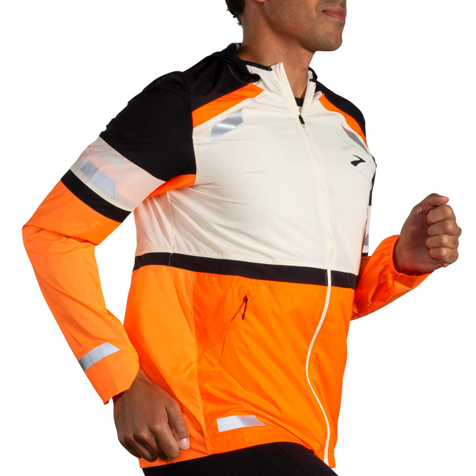 Front view of a model wearing the Brooks Men's Run Visible Jacket 2.0 in the Ecru/Fluoro Flash/Black colourway. (8499396804770)