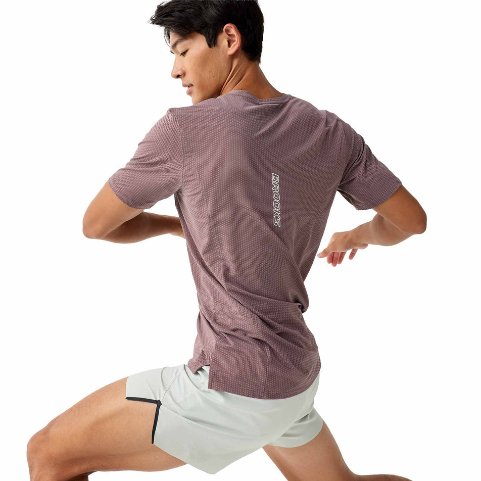 Angled view of a model wearing the Brooks Men's High Point Short Sleeve 2.0 in the Peppercorn colourway.