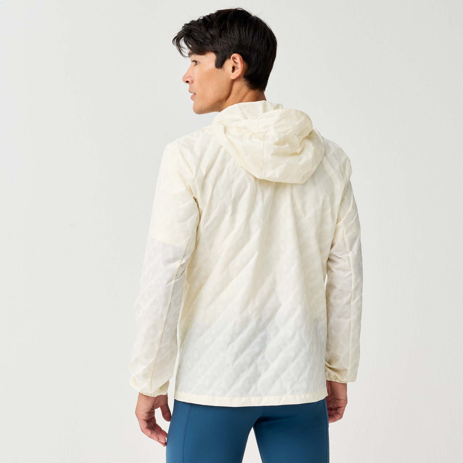 Back view of a model wearing the Brooks Men's Canopy Reflective Jacket in the Reflective Wordmark Bone colourway.