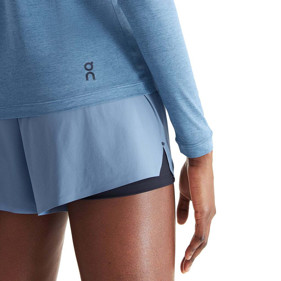 Close-up back view of a model wearing an On Women's Performance Long-T in the Stellar colourway. Lower back-right section of the top is visible, with the On logo on display.  (8003477209250)