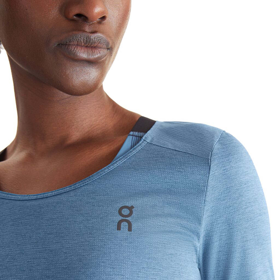 Close-up front view of a model wearing an On Women's Performance Long-T in the Stellar colourway. Upper left section of the top is visible, with the On logo on display. (8003477209250)
