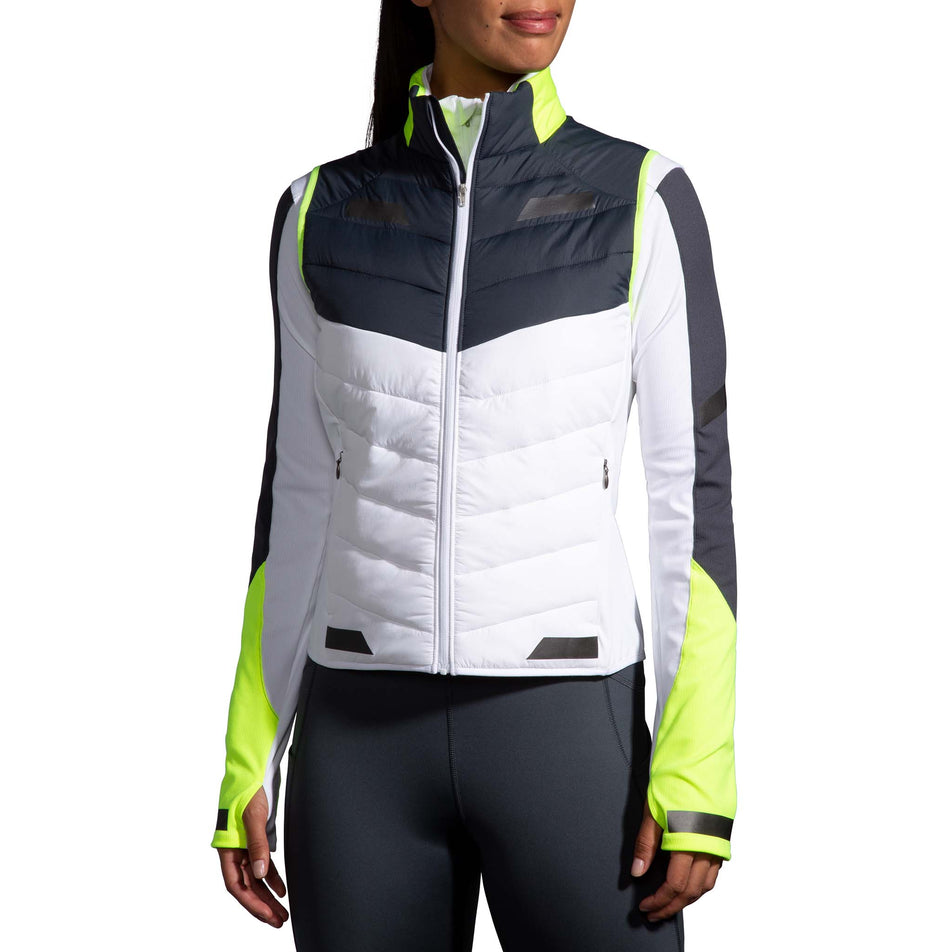 Front view of a model wearing a Women's Run Visible Insulated Vest in the White/Asphalt/Nightlife colourway. Model is also wearing a Brooks long sleeve top.  (8059825914018)