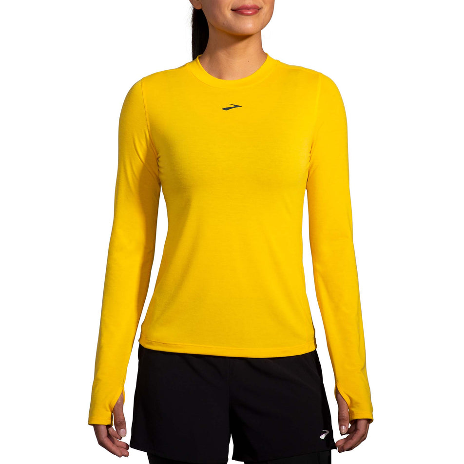 Front view of a model wearing a Brooks Women's High Point Long Sleeve Top in the Lemon Chrome colourway. Model is also wearing Brooks legwear. (8177458249890)